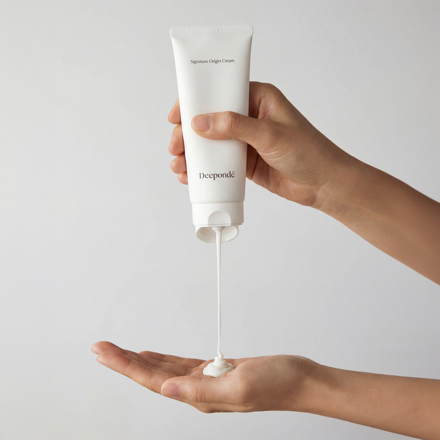 Deepondé Signature Origin Cream texture shot — lightweight white cream dispensed from tube
